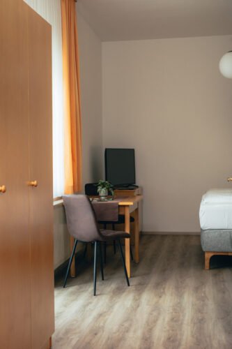 Moderner Tisch mit Stühlen im Premium-Zimmer des B&B Number 1 Bad Loipersdorf, ideal für vielseitige Nutzung.