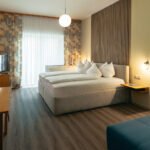 Premium-Zimmer im B&B Number 1 Bad Loipersdorf mit Boxspringbett, Holzlamellen-Wandelement und stimmungsvoller Beleuchtung