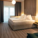 Premium-Zimmer im B&B Number 1 Bad Loipersdorf mit Boxspringbett, Holzlamellen-Wandelement und stimmungsvoller Beleuchtung